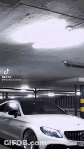 A White Car Is Parked In A Parking Garage With A Tik Tok Watermark GIF