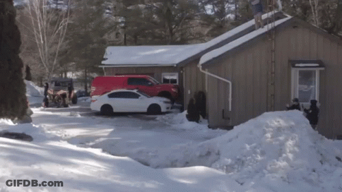A White Car Is Parked In Front Of A Brown House GIF