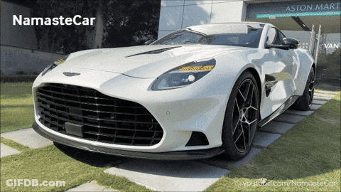 A White Car Is Parked In Front Of An Aston Mart Building GIF