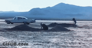 A White Car Is Parked On The Side Of A Desert Road GIF