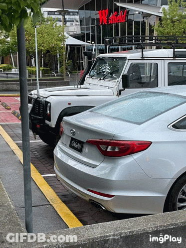 A White Car With A License Plate That Says Gagan Is Parked In A Parking Lot GIF