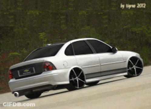 A White Car With Black Wheels Is Parked On The Road GIF