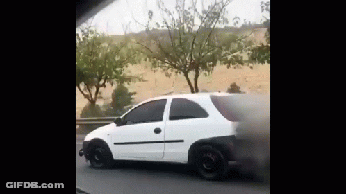A White Car With Smoke Coming Out Of It 'S Tire GIF