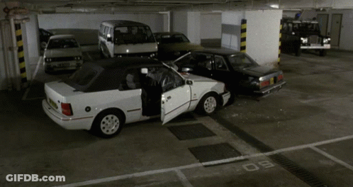 A White Car With The Door Open Is Parked In A Parking Lot GIF