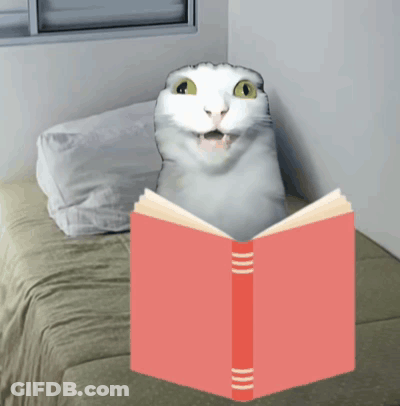 A White Cat Is Reading A Red Book On A Bed GIF