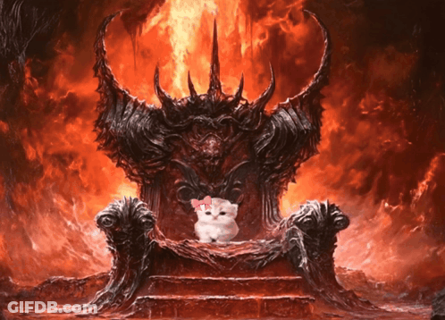 A White Cat With A Pink Bow Sits On A Throne In Front Of A Fire GIF