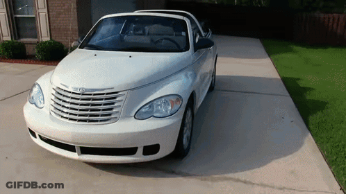 A White Chrysler Pt Cruiser Is Parked In A Driveway GIF
