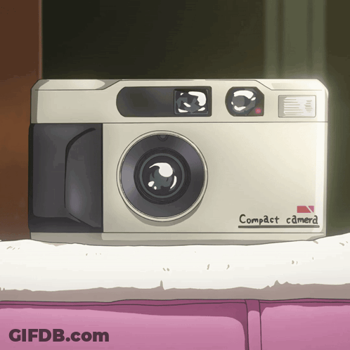 A White Compact Camera Is Sitting On A Pink Couch GIF