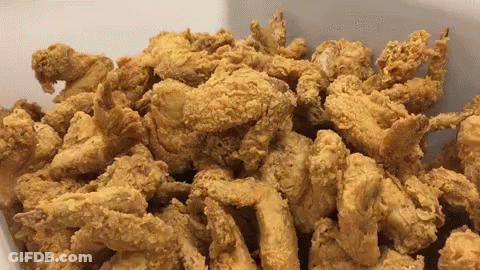 A White Container Filled With Fried Chicken Pieces GIF