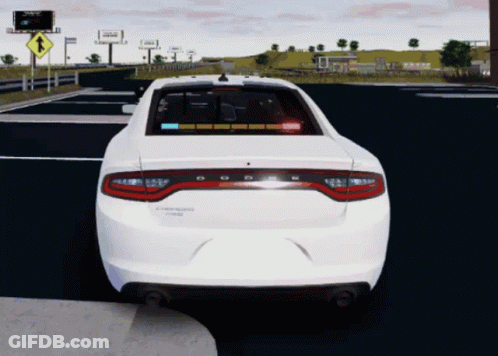A White Dodge Charger Is Driving Down The Road GIF