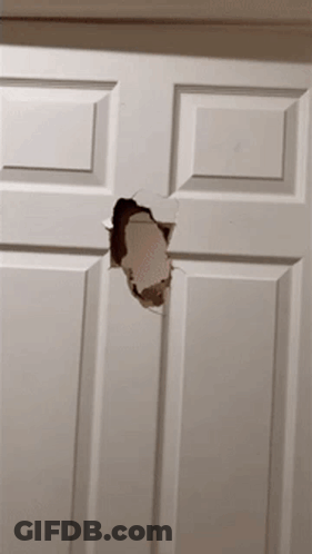 A White Door With A Hole In It That Looks Like A Hole In A Wall GIF