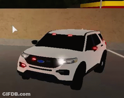 A White Ford Explorer Police Car Is Driving Down A Road . GIF