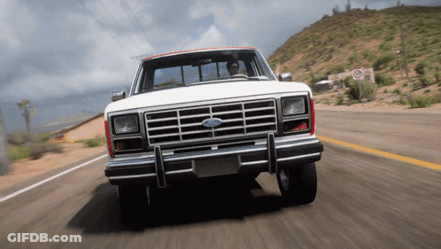 A White Ford Truck Is Driving On A Desert Road GIF