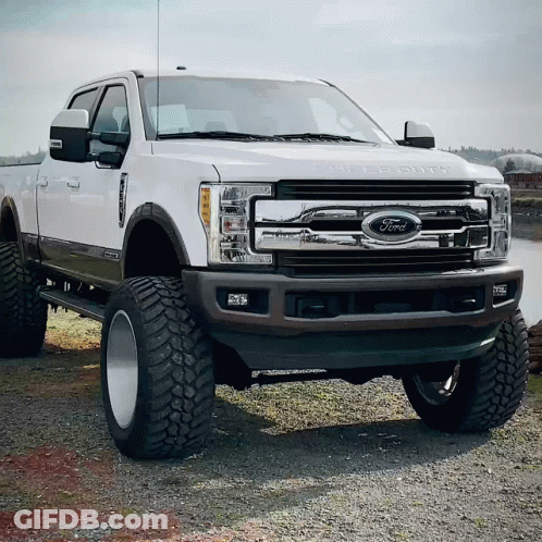 A White Ford Truck Is Parked In The Dirt GIF