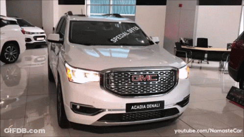 A White Gmc Acadia Denali With A Special Offer On The Windshield GIF