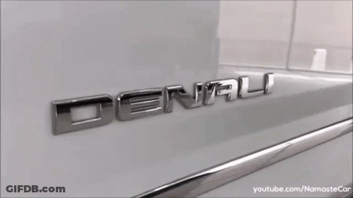 A White Gmc Denali Suv Is Parked In A Parking Lot GIF