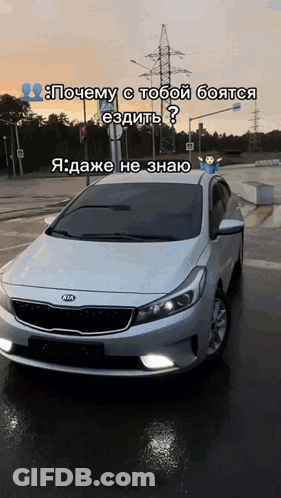 A White Kia Car Is Parked On The Side Of A Road GIF