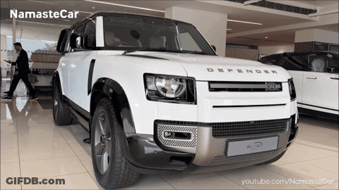 A White Land Rover Defender In A Showroom GIF