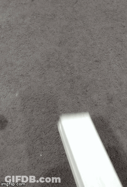 A White Object Is Sitting On A Carpet On The Floor . GIF