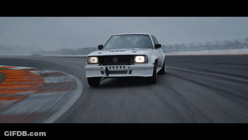 A White Opel Car Is Driving Down A Track GIF