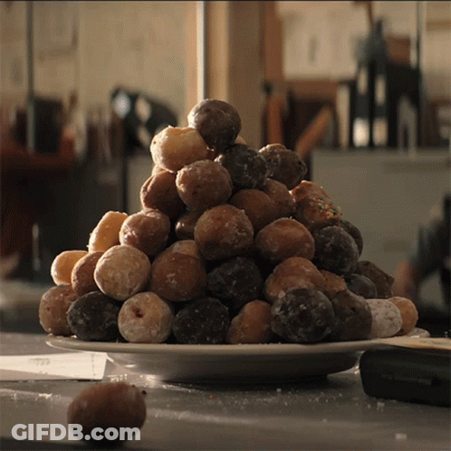 A White Plate Filled With A Variety Of Donuts GIF
