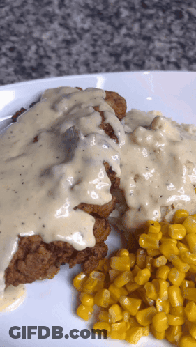 A White Plate Topped With Fried Chicken And Corn GIF