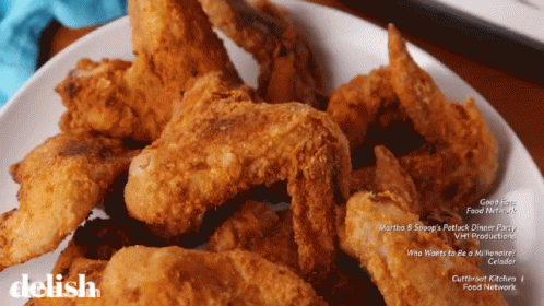 A White Plate Topped With Fried Chicken Wings Says Delish On The Bottom GIF