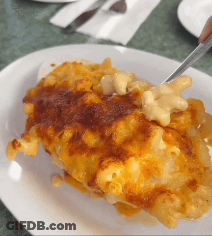 A White Plate Topped With Macaroni And Cheese And A Fork GIF