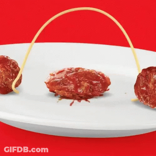 A White Plate Topped With Meatballs And Spaghetti String GIF