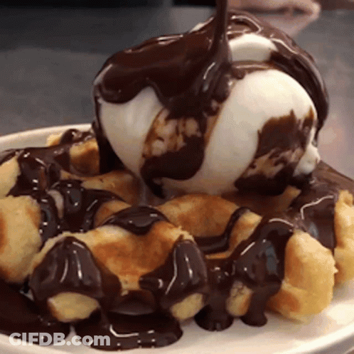 A White Plate Topped With Waffles And Ice Cream With Chocolate Sauce GIF