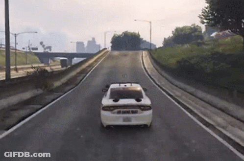 A White Police Car Is Driving Down A Road GIF