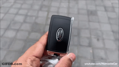 A White Range Rover Velar Is Parked On A Cobblestone Driveway . GIF