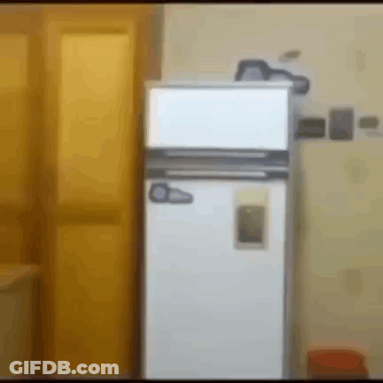 A White Refrigerator Is Sitting In A Room Next To A Yellow Door GIF