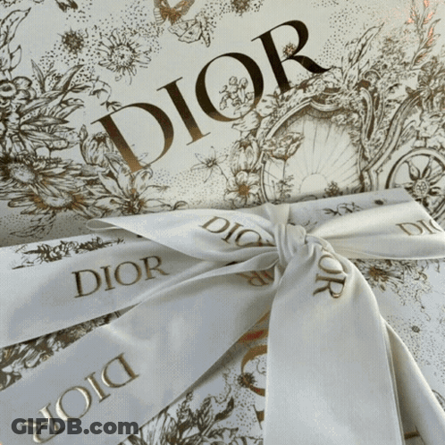 A White Ribbon With Dior Written On It Is Tied In A Bow GIF