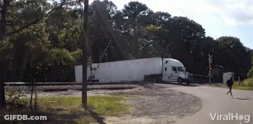 A White Semi Truck Is Crossing A Railroad Crossing With A Viralhog Logo In The Background GIF
