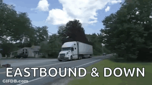A White Semi Truck Is Driving Down A Road With The Words Eastbound & Down Written Below It GIF