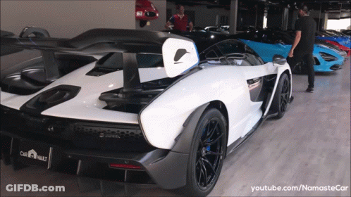 A White Sports Car In A Showroom With Youtube.com/namastecar GIF
