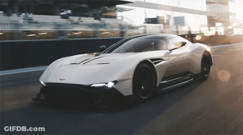 A White Sports Car Is Driving Down A Race Track With The Letters Oso On The Bottom GIF