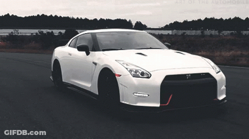 A White Sports Car Is Driving Down A Road With The Words Art Of The Automobile Visible In The Background GIF