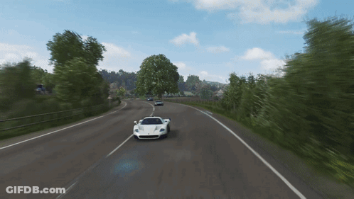 A White Sports Car Is Driving Down The Road GIF