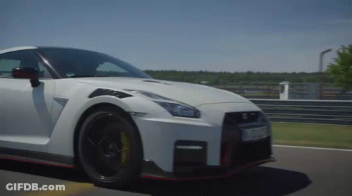 A White Sports Car Is Driving On A Road GIF