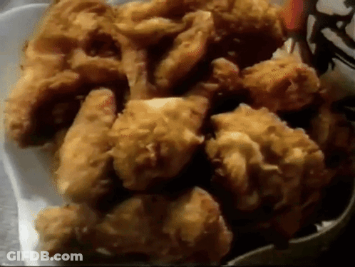 A White Styrofoam Container Filled With Fried Chicken GIF
