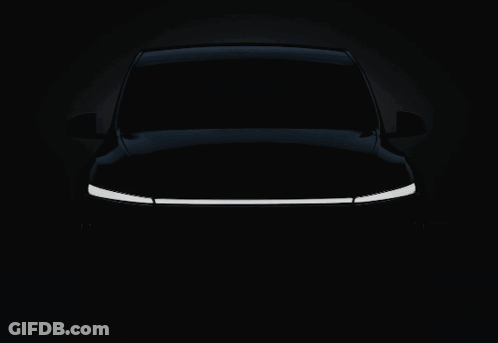 A White Tesla Car With The Word Tesla On The Front GIF