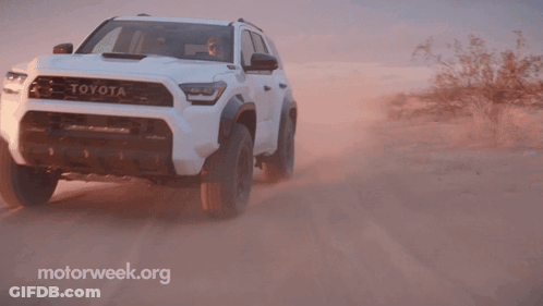 A White Toyota Is Driving On A Dirt Road In The Desert GIF
