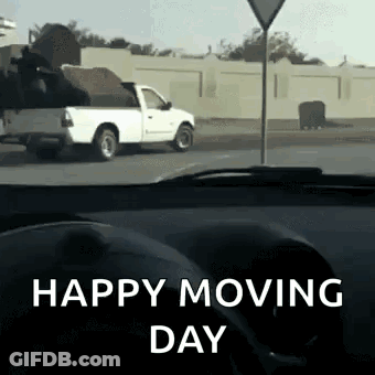 A White Truck Is Driving Down The Road With The Words Happy Moving Day Written On The Bottom GIF