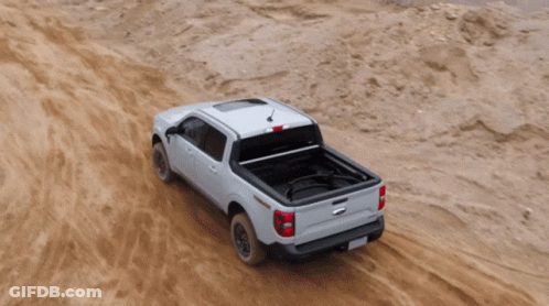 A White Truck Is Driving Through A Dirt Field GIF
