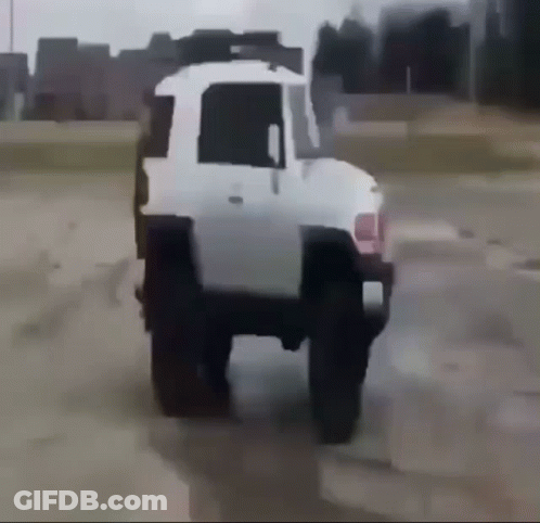 A White Truck Is Driving Through A Dirt Field GIF