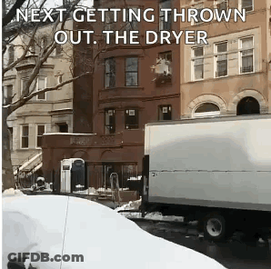 A White Truck Is Parked In Front Of A Building With The Words Next Getting Thrown Out The Dryer GIF