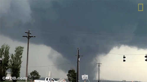 A White Truck Is Parked In Front Of A Large Storm GIF