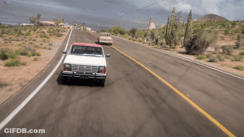 A White Truck With A Red Top Is Driving Down The Road GIF